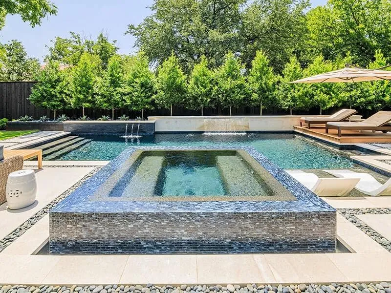 Modern pool and raised spa with tiled edge and lounge chairs